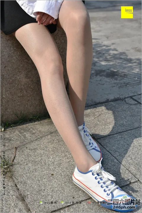 阿拉弗裤腿和白色运动鞋坐在石墙上