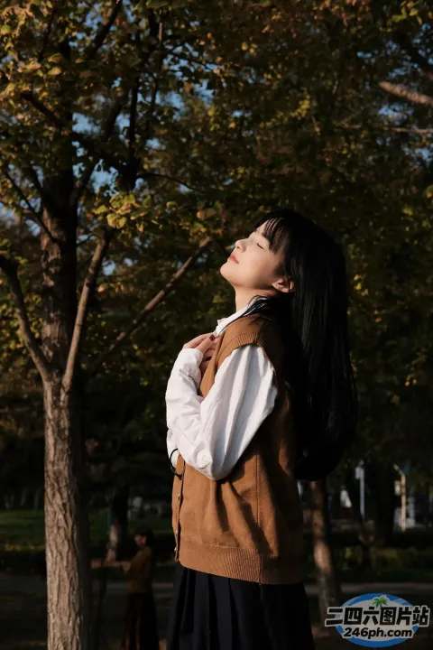 有一个女人站在公园里，背对着镜头