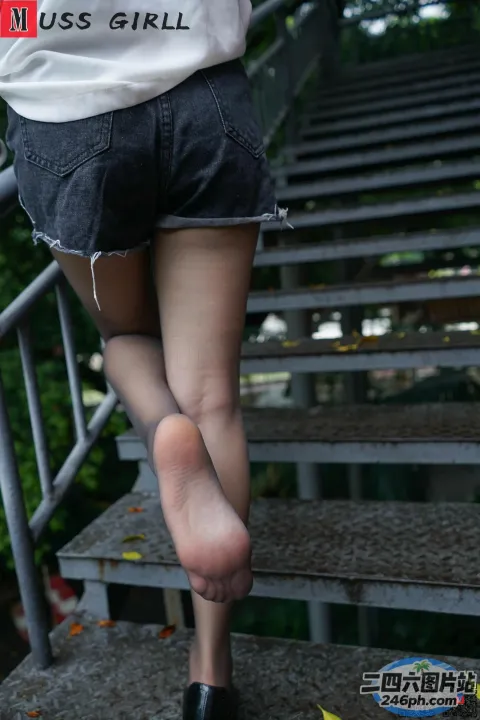 一名走上楼梯的女人的双腿和高跟鞋