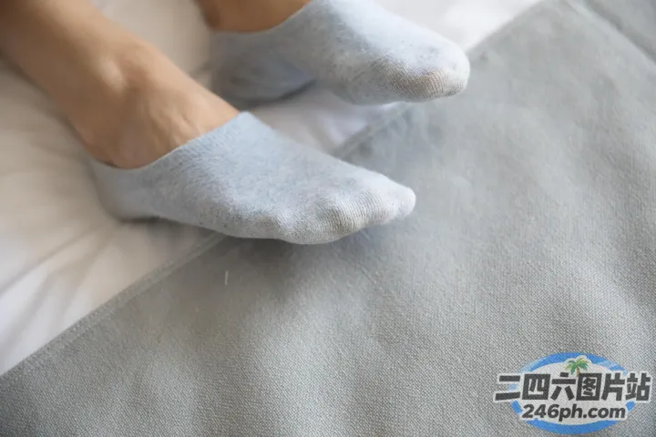 有人躺在床上，双脚抬起