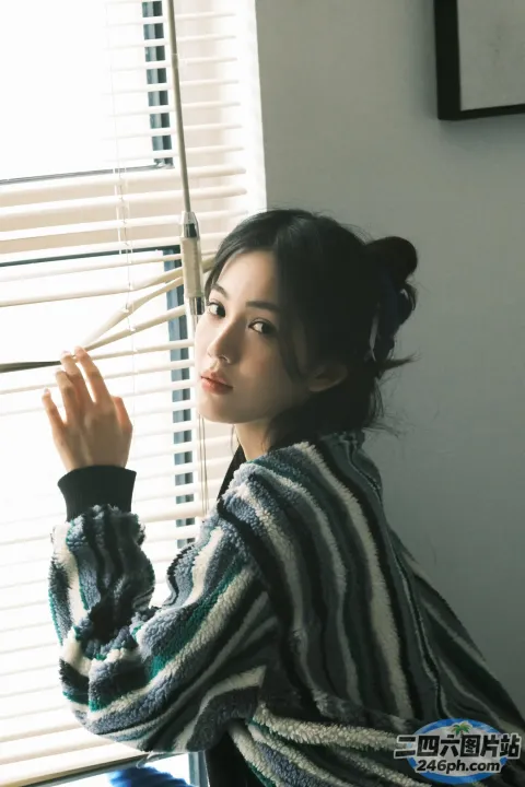 阿拉菲女子坐在窗前，手里拿着筷子