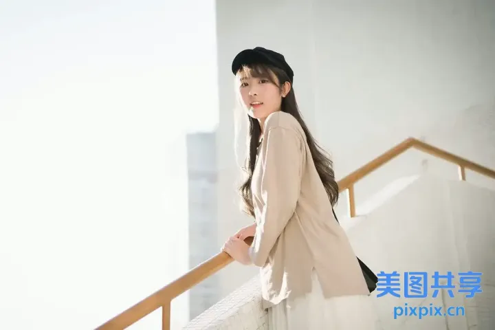 阳台上站着一个戴着帽子的女人