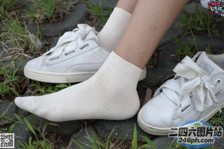 有人穿着白色运动鞋和一双袜子