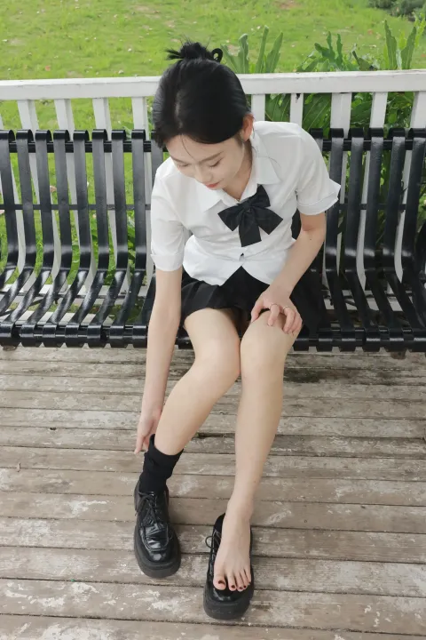 有个女人坐在长凳上，双腿交叉