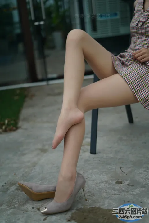 一个女人坐在椅子上，双腿交叉的特写