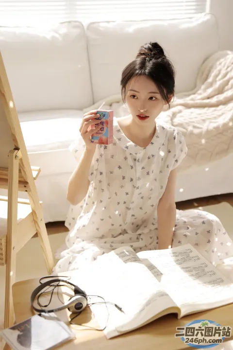 地板上坐着一个女人，手里拿着一本书