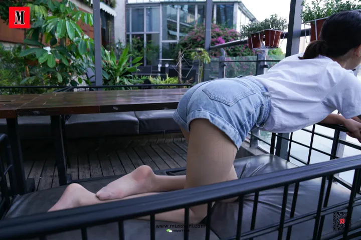 有个女人正弯着腰坐在长凳上