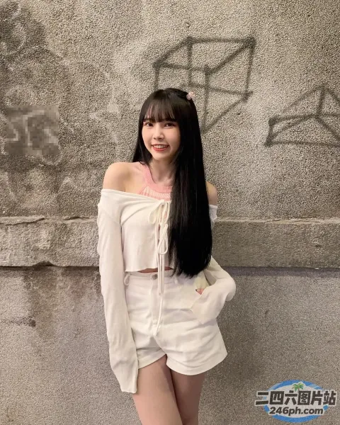 黑发长发的 Araffe 女人在墙前摆姿势