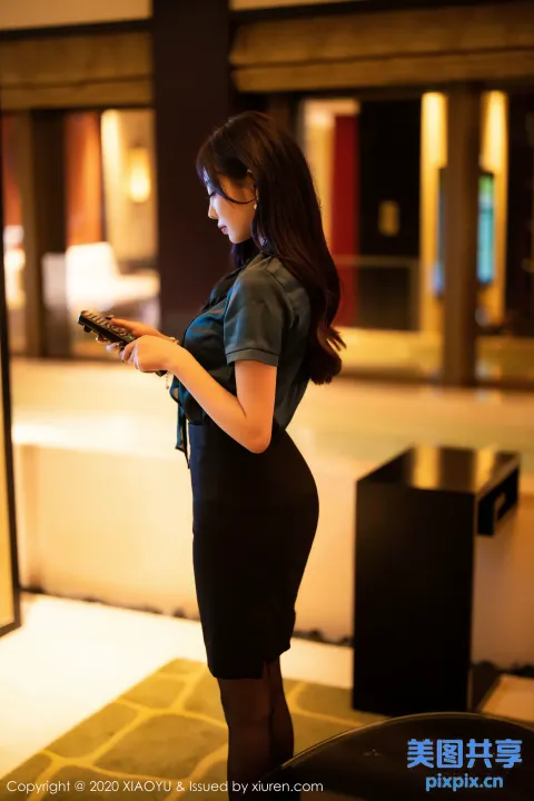 身穿黑色连衣裙的 Araffe 女子看手机
