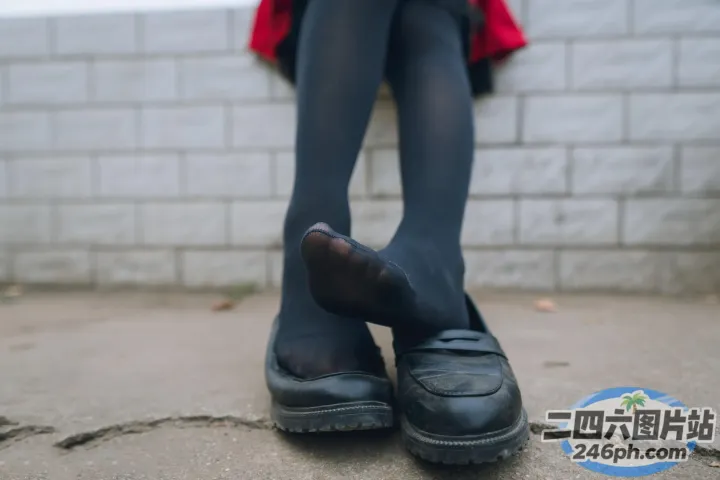 地上坐着一个穿着黑色鞋子的女人