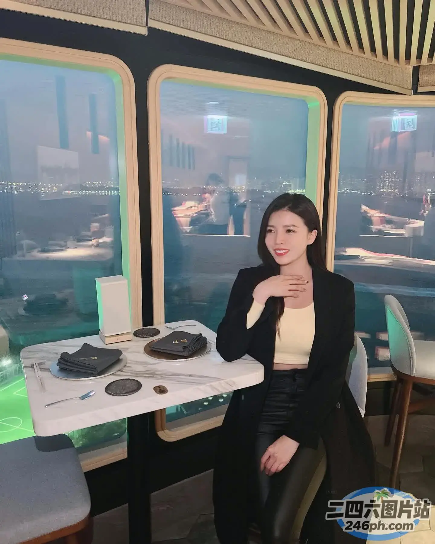 有个女人坐在一张桌子旁，桌上放着一盘食物