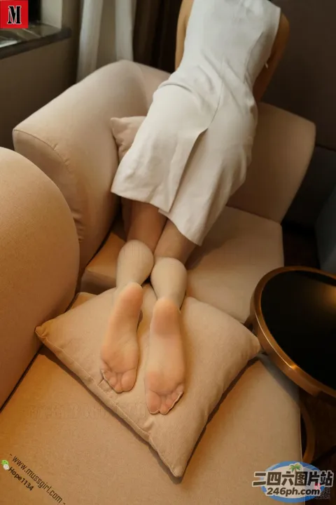 有个女人坐在椅子上，脚放在枕头上