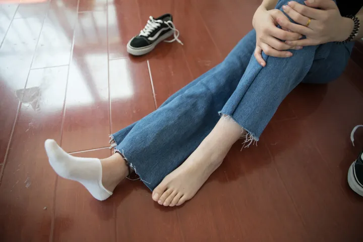 有一个女人交叉双脚坐在地板上