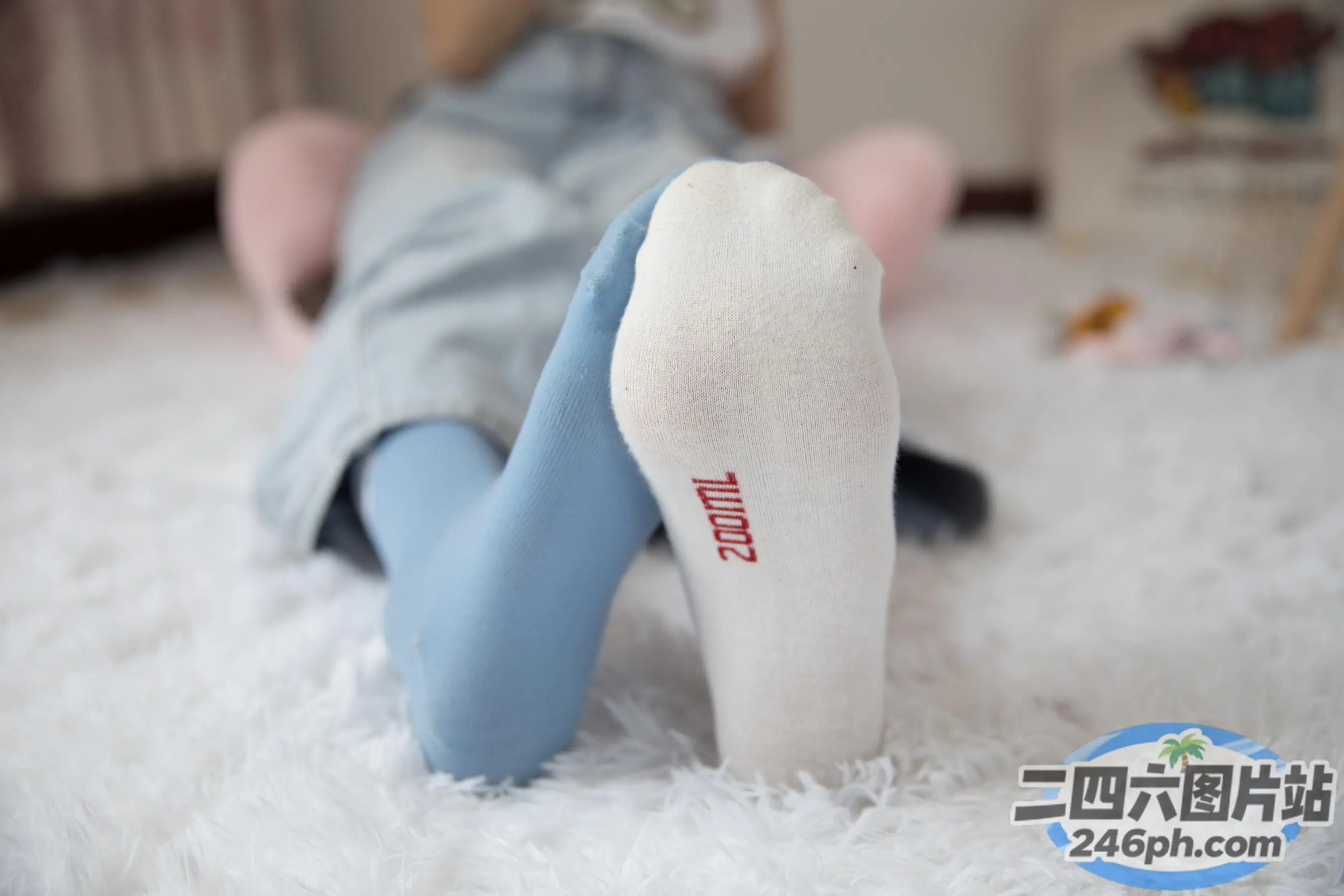 有人躺在白色地毯上，双脚抬起
