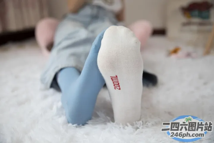 有人躺在白色地毯上，双脚抬起