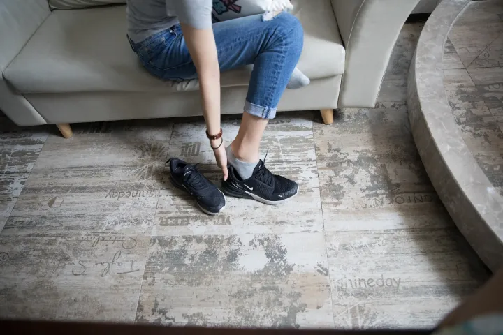 有人在客厅的沙发上系鞋带