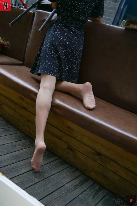 有个女人坐在长凳上，手里拿着手机