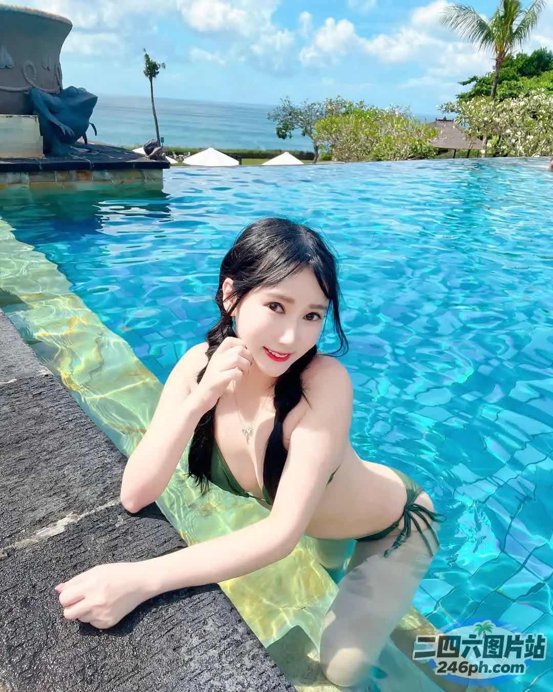 一个穿着比基尼的女人坐在游泳池旁边的游泳池里