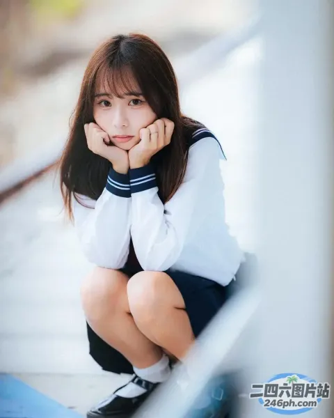 身穿校服的 Arafed 亚裔妇女蹲在蓝色垫子上