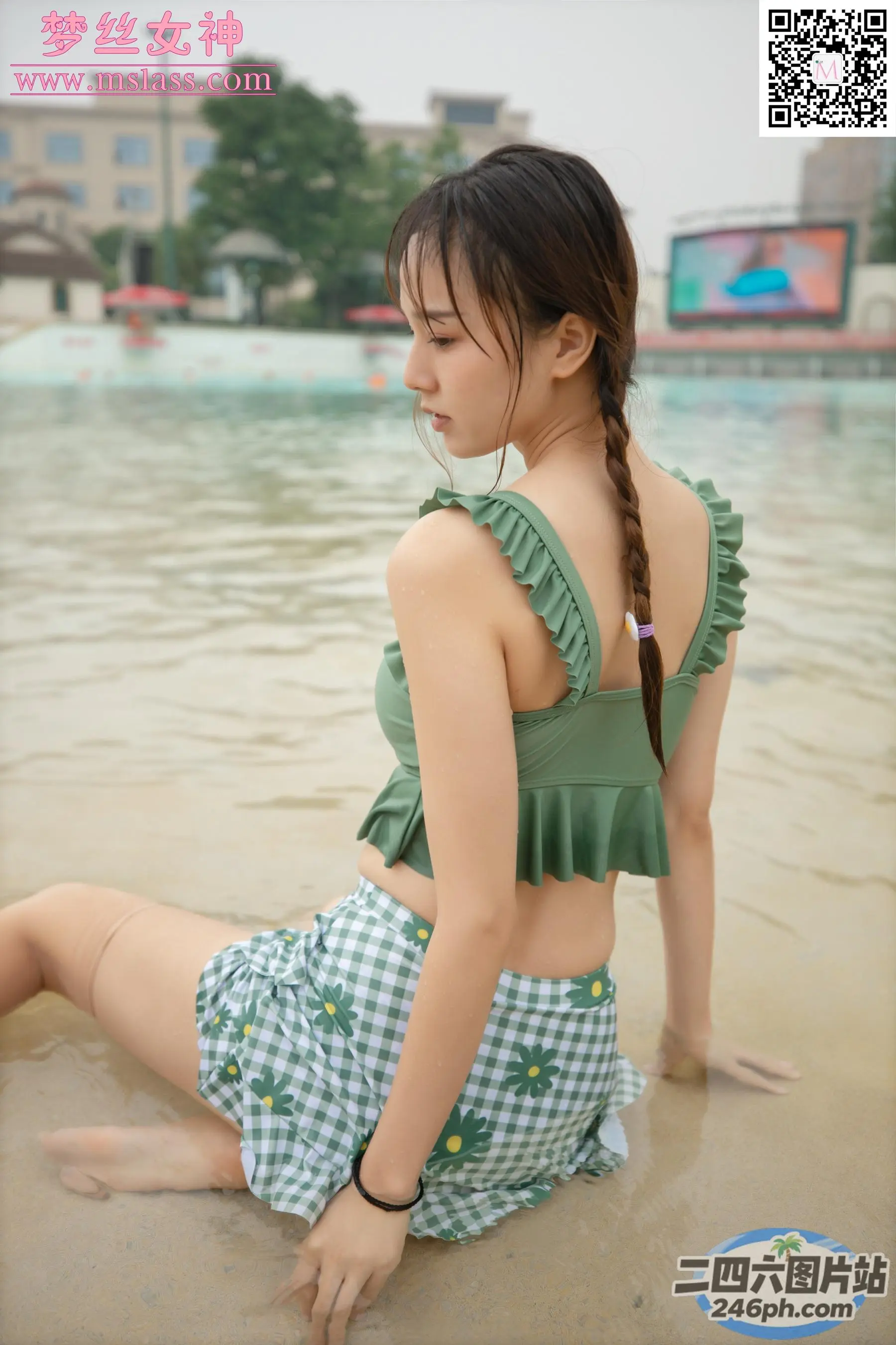一名女子坐在水体附近的海滩上的特写镜头