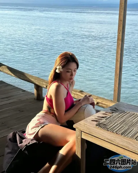 女人坐在木凳上，腿上放着一台笔记本电脑