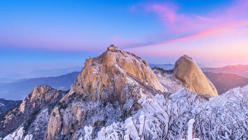 日落时分，群山白雪皑皑，天空呈粉红色