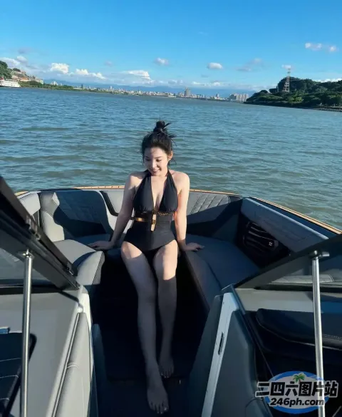 身穿黑色泳衣的女子坐在水中的船上