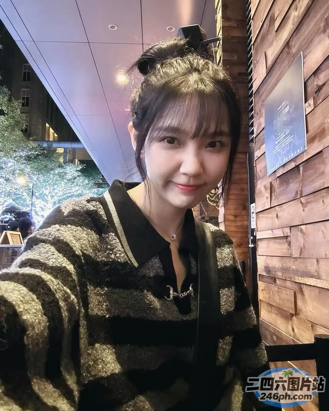 有个女人坐在一张桌子旁，桌上放着一盘食物