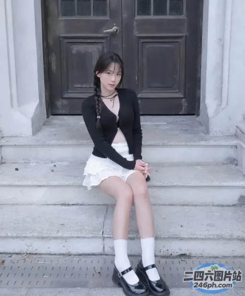 有个女人坐在一栋楼的台阶上