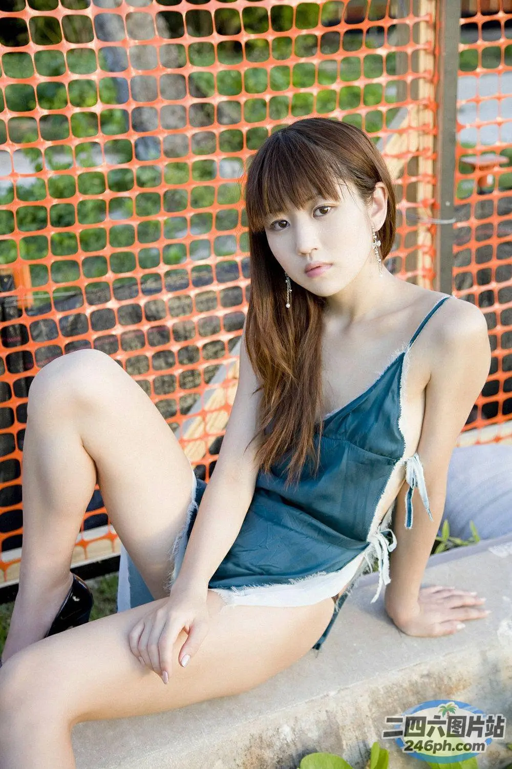 穿着绿色连衣裙坐在窗台上的 arafed 亚洲女子