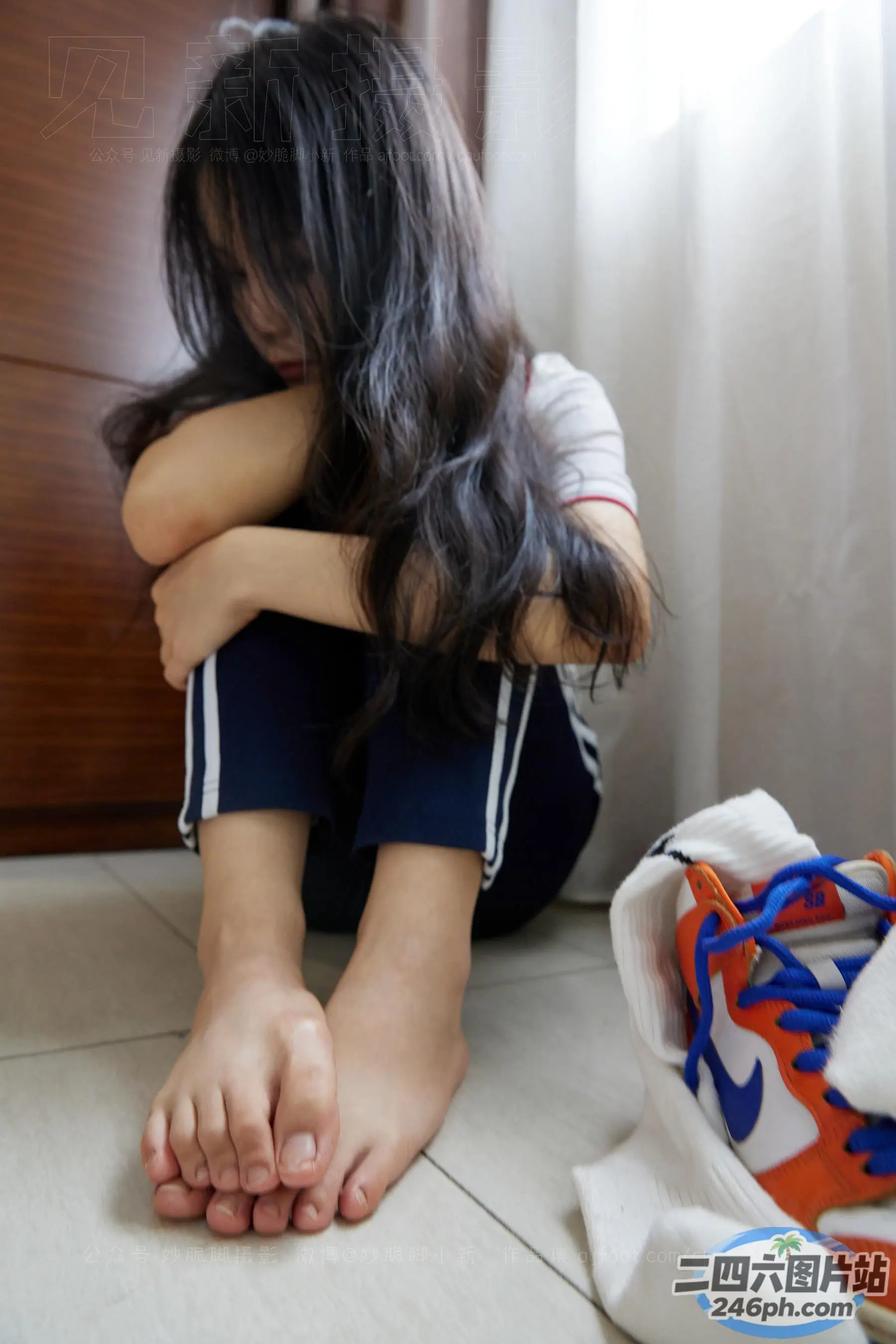 有一个女人坐在地板上，双叉