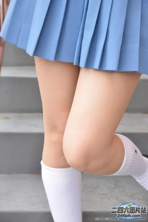 穿着蓝色裙子和白色袜子的 arafed 女人正在走上楼梯