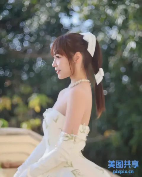 有个身穿白裙的女人站在一棵树前
