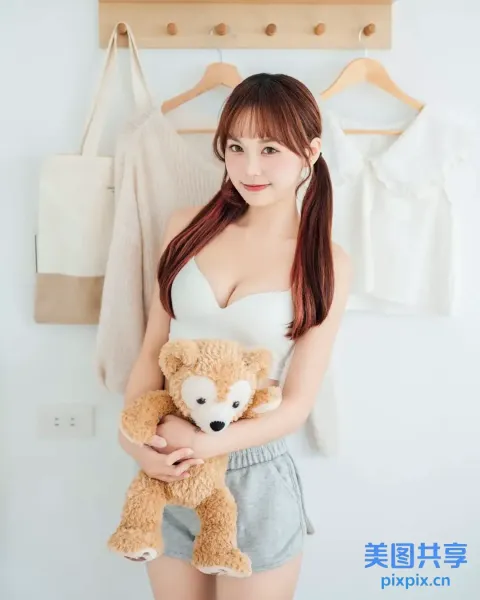 阿拉夫德亚洲妇女在墙前抱着一只泰迪熊