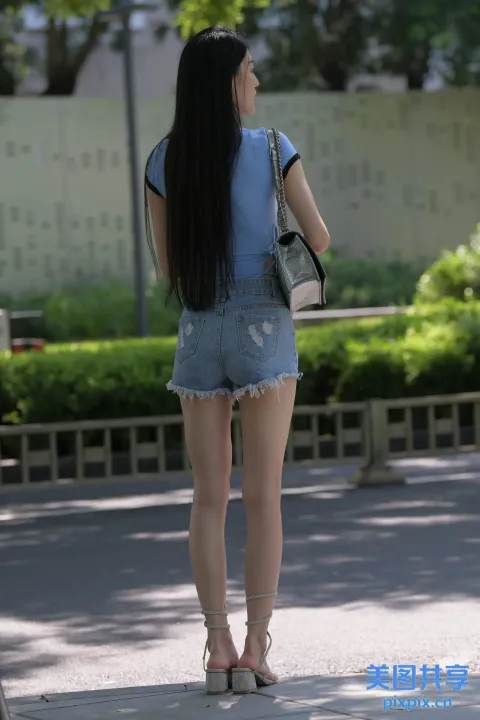 长着黑色长发的 Araffed 女人走在人行道上