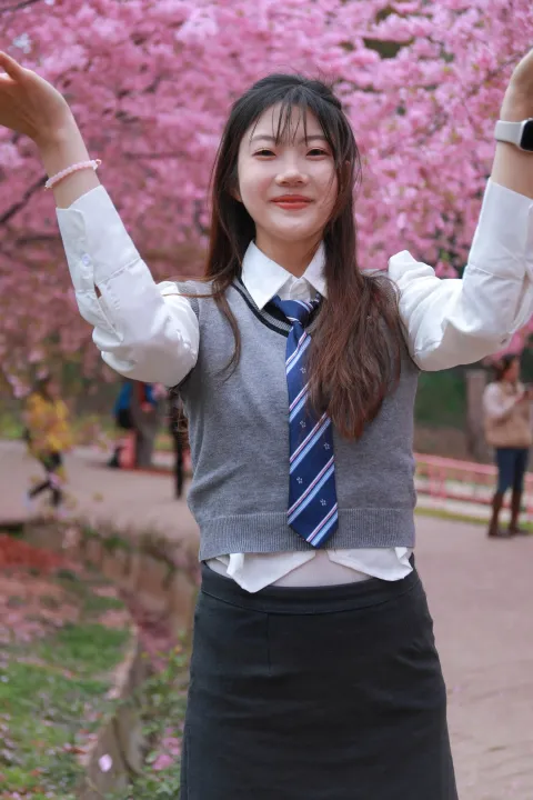 身穿校服，张开双臂的 arafed 亚洲妇女