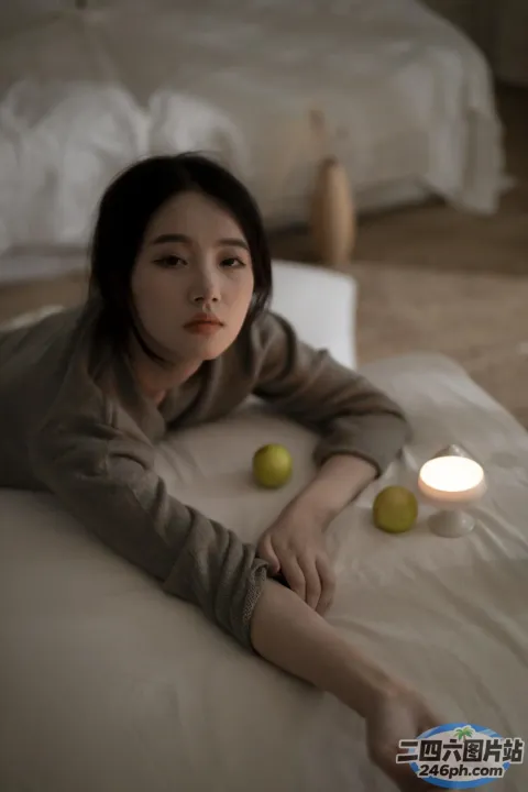 女人躺在床上，手里拿着两个苹果和一根蜡烛