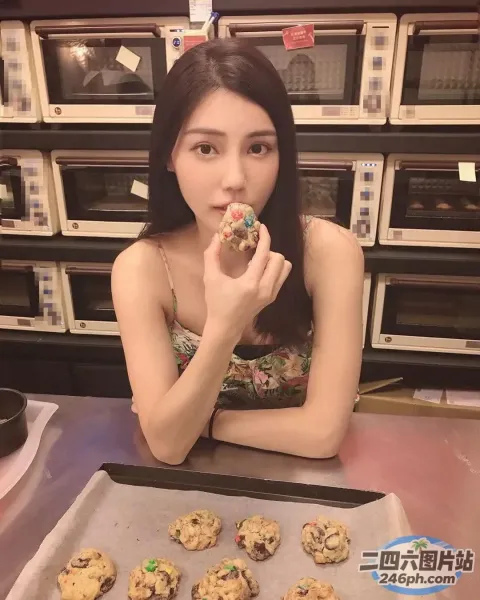 坐在桌子旁的女人，手里拿着一盘饼干和一块饼干