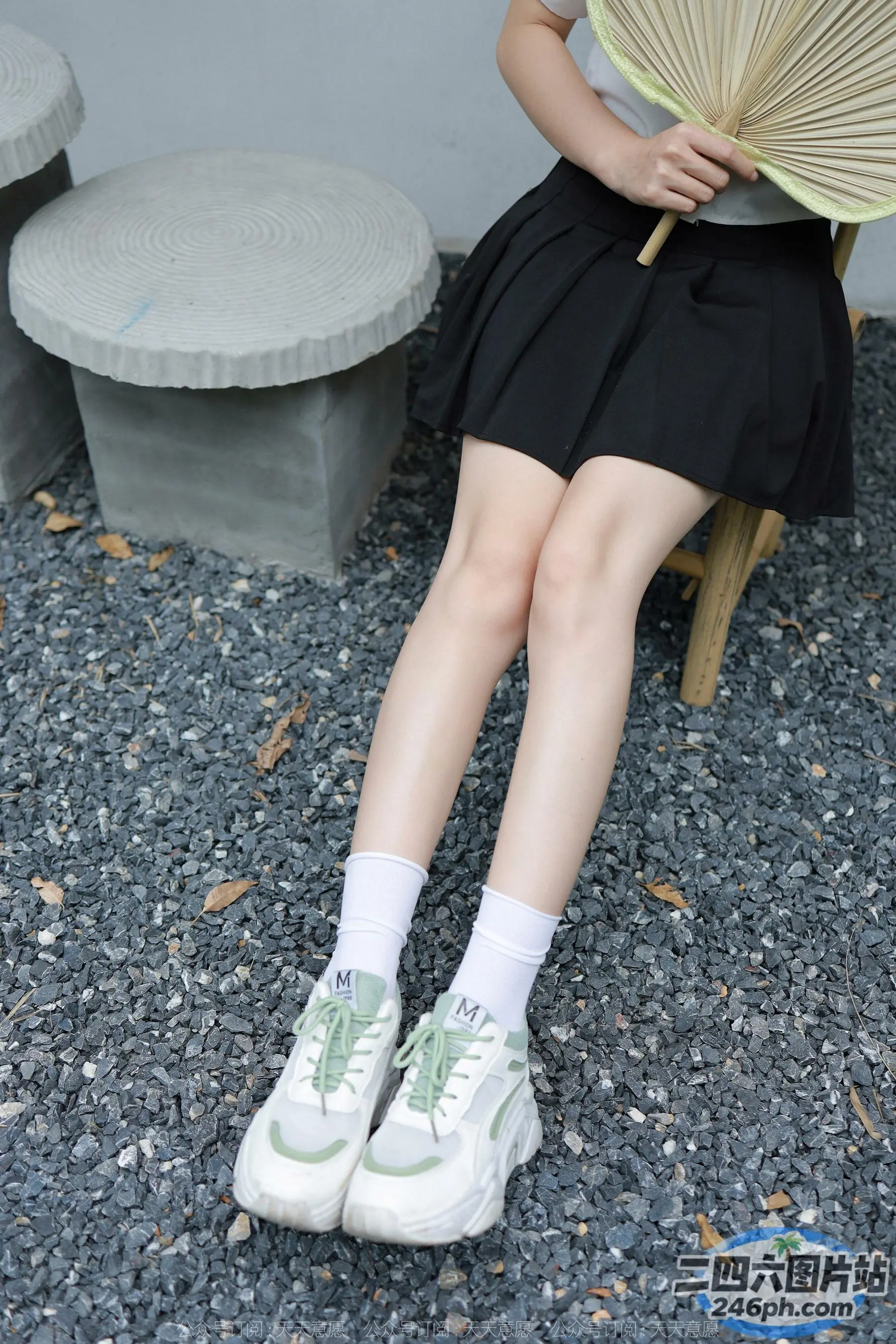 有个女人坐在长凳上，手里拿着一把扇子
