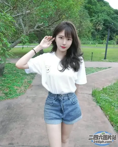 身穿白衬衫和牛仔短裤的 araffe 女子合影留念