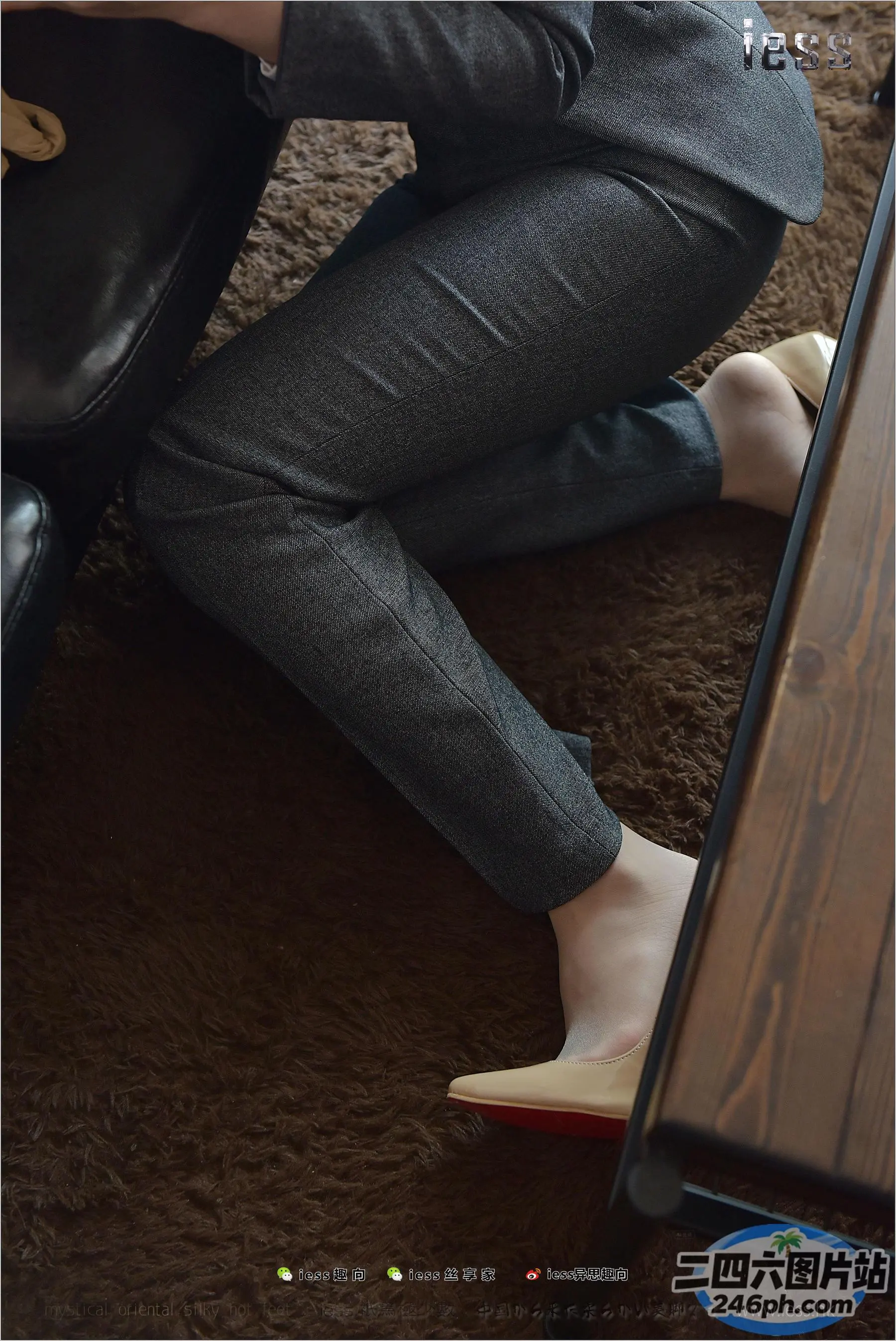 一位拿着笔记本电脑坐在沙发上的女人的双腿