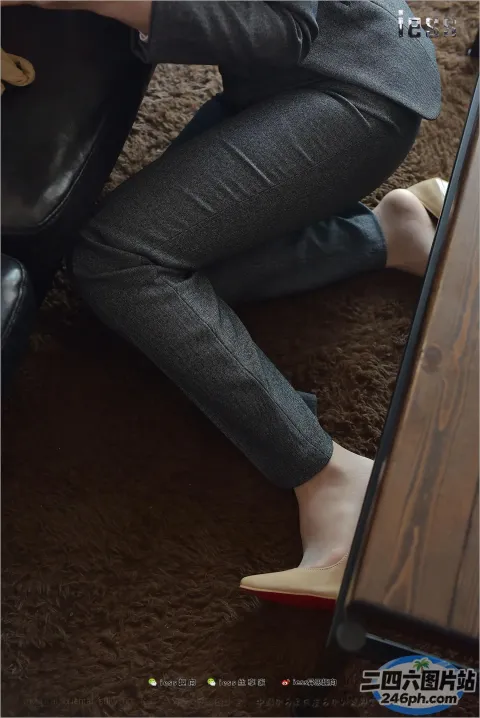 一位拿着笔记本电脑坐在沙发上的女人的双腿