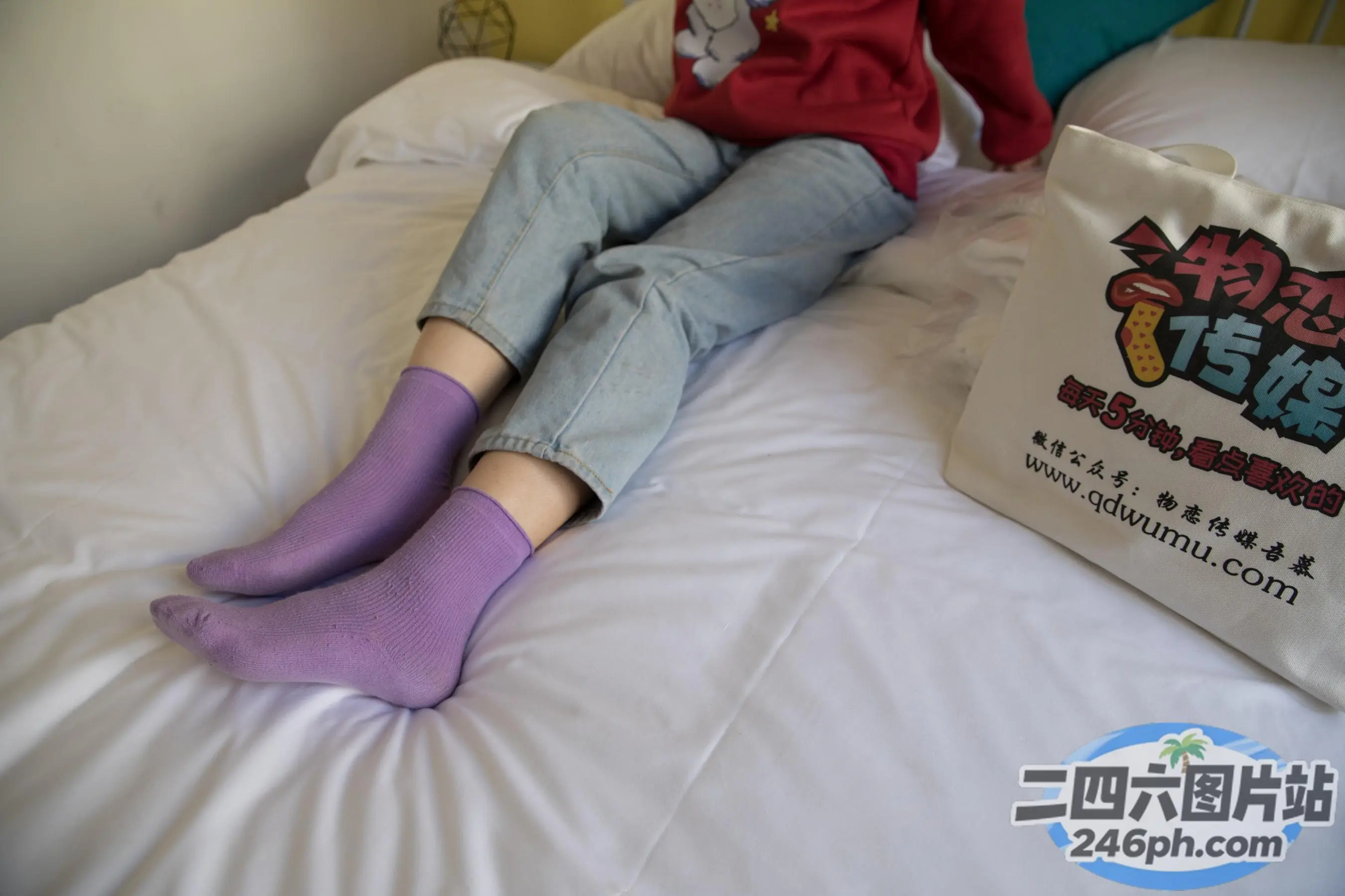 阿拉菲坐在床上，手里拿着一袋纸巾和一双袜子