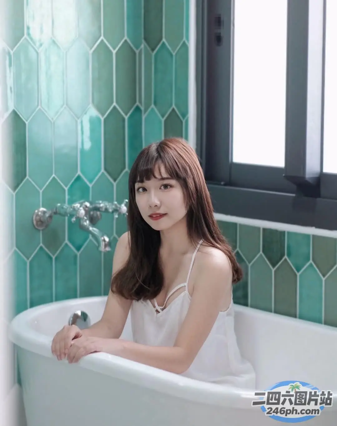 阿拉菲女人坐在浴缸里拿着一瓶水