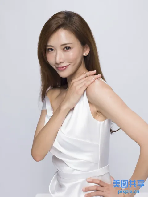 有一位身穿白色连衣裙的女子摆姿势拍照