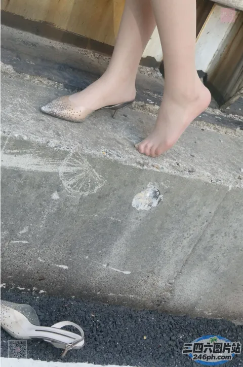 人行道上站着一个女人，脚着地