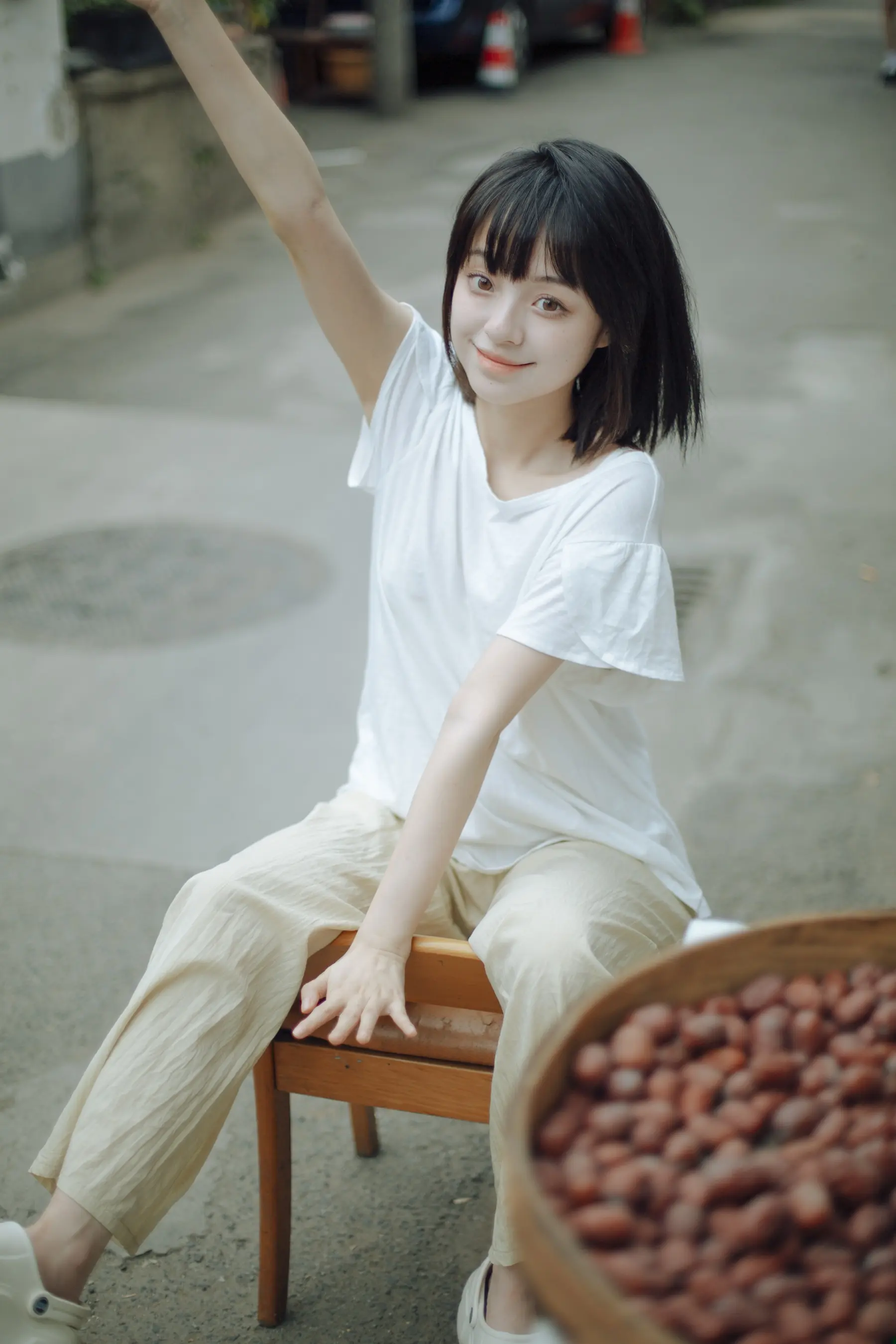 阿拉夫德女人坐在椅子上，手里拿着一碗花生