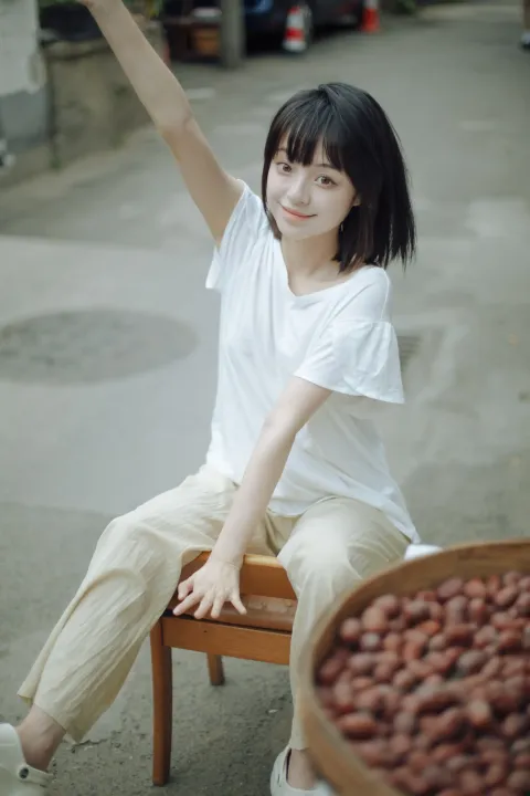 阿拉夫德女人坐在椅子上，手里拿着一碗花生