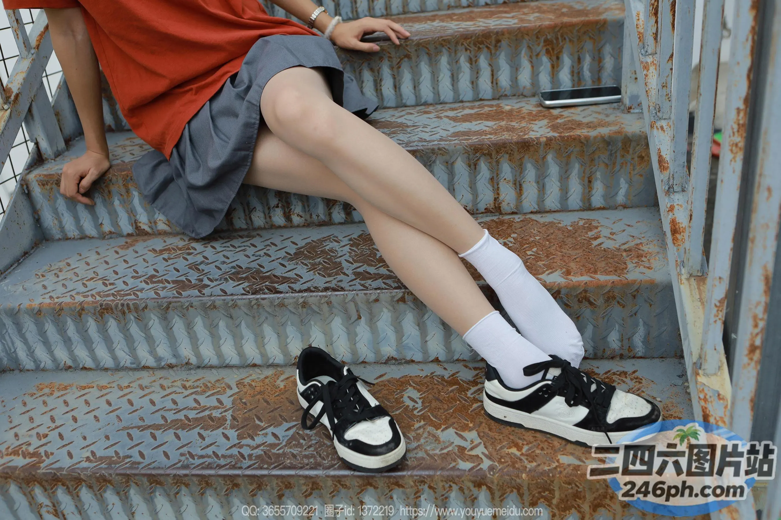 阿拉夫德女人坐在楼梯上，双脚在打电话