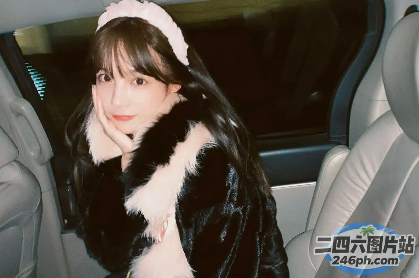 有一个女人坐在车里，腿上放着一只猫